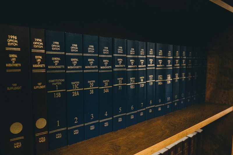 Stack of outdated reference books gathering dust on a shelf