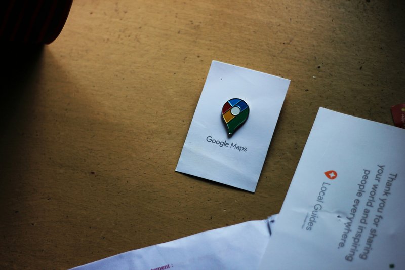 A smartphone held in a hand on a city street, the screen showing a Google Maps local 3-pack result for 'local service provider near me' with three small business listings displayed above the fold.